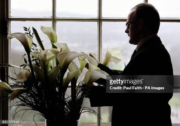 West Tyrone MLA Barry McElduff of Sinn Fein admires some lillies at an Easter commemoration in Parliament buildings in Stormont, Belfast.