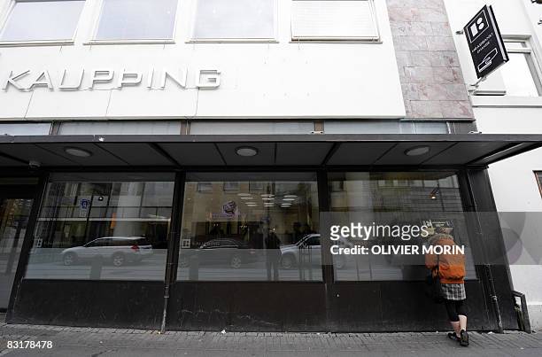 Woman uses an automatic teller machine outside a branch of the Icelandic bank Kaupthing on October 8, 2008 in Rejkjavik. The Icelandic state has...