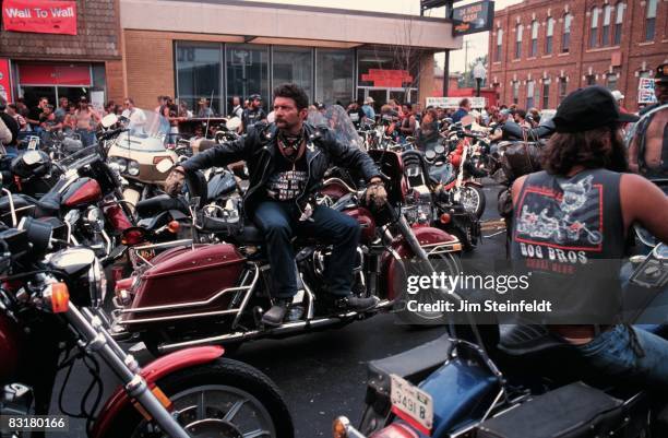 50th Anniversary of the World Famous Sturgis Motorcycle Rally. Moustached man wearing a black leather jacket and scarf sitting on his Harley Davidson...