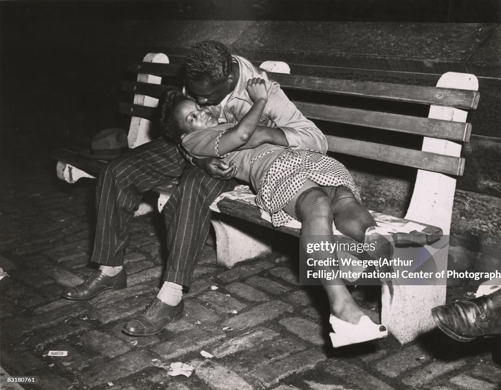 A woman and man kissing on a park bench at night, near Central Park ...