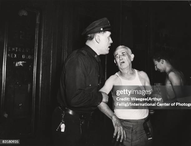 On New York's East Side, a policeman tries to console Henry Geller, the landlord at 312 E. Houston Street, who was distraught over the death of the...