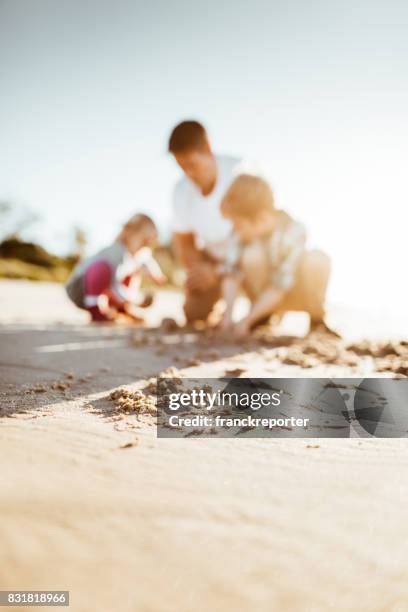 familie, spielen mit dem sand am strand - australia summer reflection stock-fotos und bilder