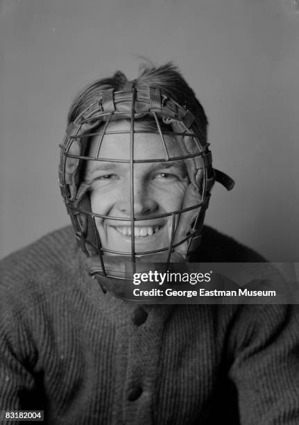 Young boy smiles while trying out an old-fashioned baseball catcher's mask, United States, ca.1930s.