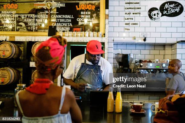 Woman buys a drink from the hipster coffee store "House of Machines" on March 31, 2017 in Cape Town, South Africa. Those born since the collapse of...