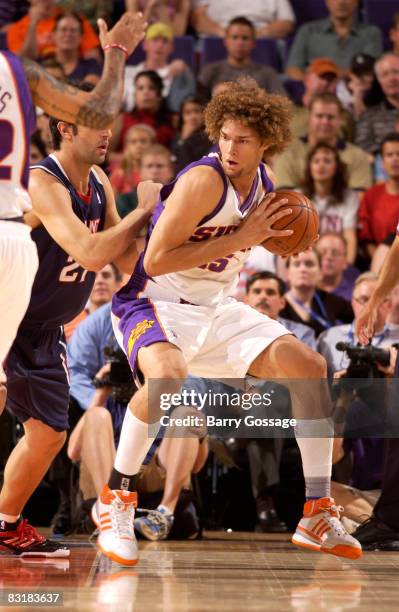 Robin Lopez of the Phoenix Suns drives against Zaza Pachulia of the Atlanta Hawks in an NBA game played on October 8 at U.S. Airways Center in...