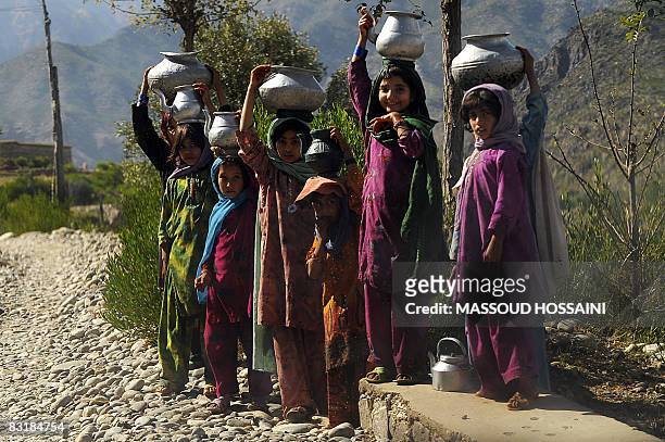 Afghan girls stand as they watch on the road from Shultan to Asad Abad city in Kunar province, east of capital Kabul on October 8, 2008. About twenty...