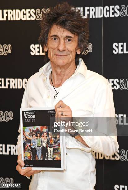 Ronnie Wood poses with a copy of his new book 'Ronnie Wood: Artist' at Selfridges on August 15, 2017 in London, England.