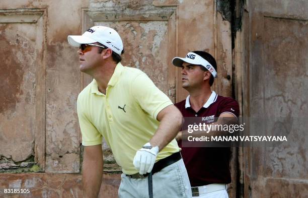 Swedish golfer Daniel Chopra and New Zealand's Mark Brown watch a tee-off during the first round of the Hero Honda Indian Open at The Delhi Golf Club...