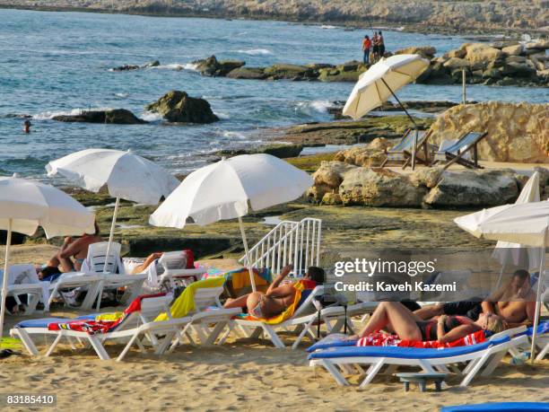 Lebanese sunbathe while lying on sundecks on the beach at Lazy Bee beach resort situated on the outskirts of Beirut towards Sidon on August 17, 2008....