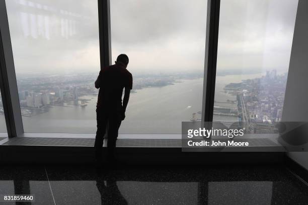 An immigrant looks down from One World Observatory after a naturalization ceremony held atop the One World Trade Center on August 15, 2017 in New...