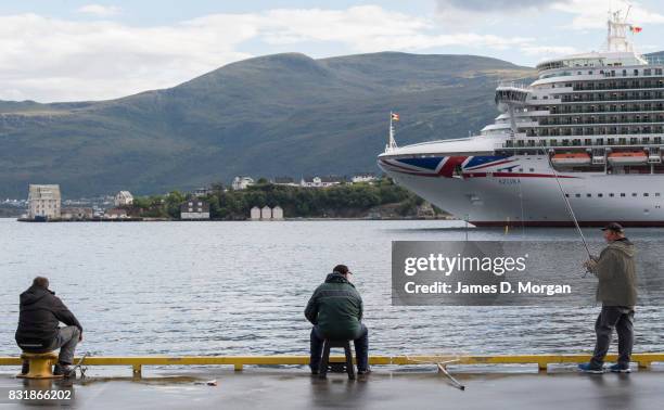 Fishermen watch as P&O Cruises Azura departs port on August 15, 2017 in Alesund, Norway. With over 3000 guests and 1200 crew, the 115,000 tonne ship...