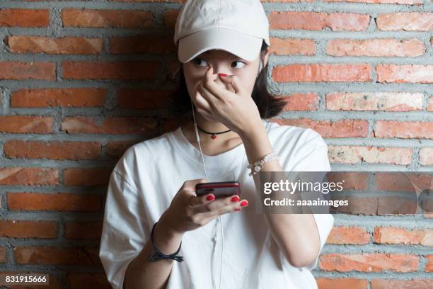 portrait of young woman standing against red wall - fashion kids stock pictures, royalty-free photos & images