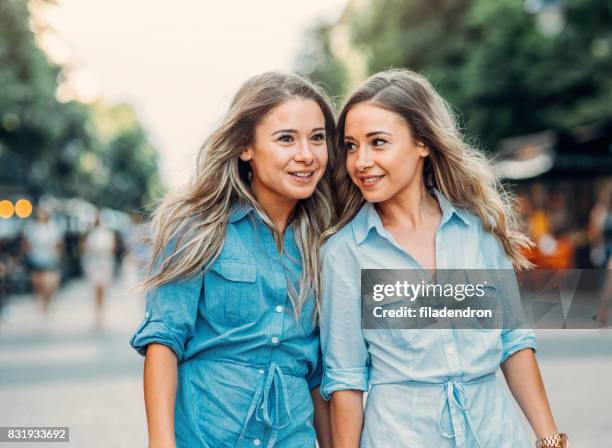 happy twins in the city - identical twin stock pictures, royalty-free photos & images