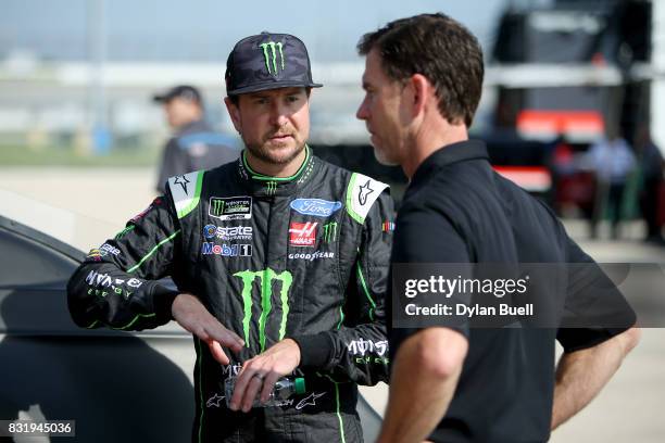 Kurt Busch, driver of the Monster Energy/Haas Automation Ford, speaks with a team member during testing for the Monster Energy NASCAR Cup Series at...