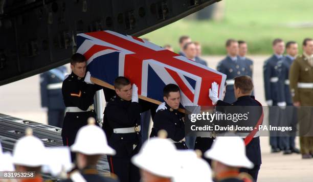 The coffin of Marine Paul Collins is carried from a C-17 Globemaster transport plane at RAF Brize Norton in Oxfordshire.