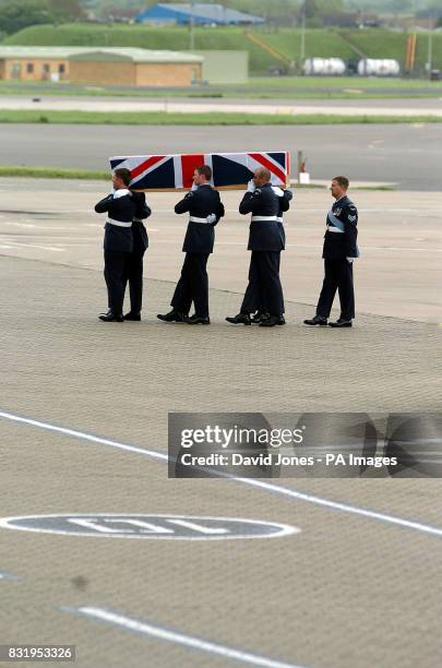 The coffin of Wing Commander John Coxen of the Army Air Corps is carried from a C-17 Globemaster transport plane at RAF Brize Norton in Oxfordshire.