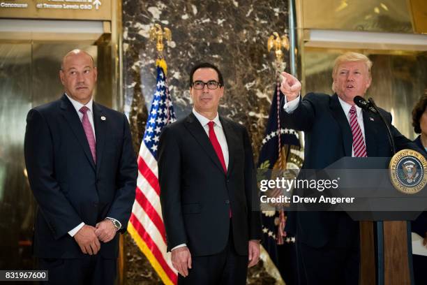 Director of the National Economic Council Gary Cohn and Treasury Secretary Steve Mnuchin look on as US President Donald Trump delivers remarks...