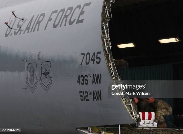 Army carry team moves the transfer case containing the remains of U.S. Army Sgt. Allen L. Stigler Jr, during a dignified transfer at Dover Air Force...