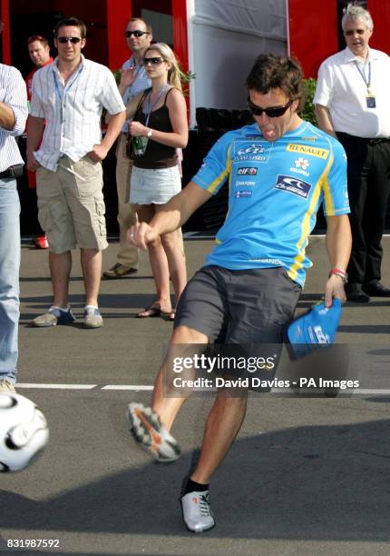 Spain's Fernando Alonso kicks a ball about in the paddock during a practice session at Silverstone ahead of the British Grand Prix which will be held...