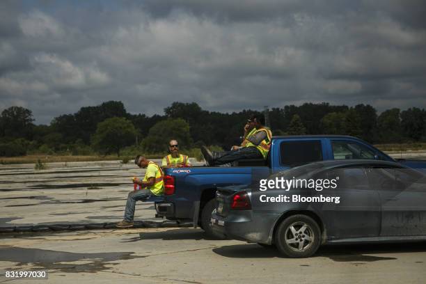 Contractors sit in a pickup truck while on break at the construction site of the American Mobility Center in Ypsilanti, Michigan, U.S., on Tuesday,...