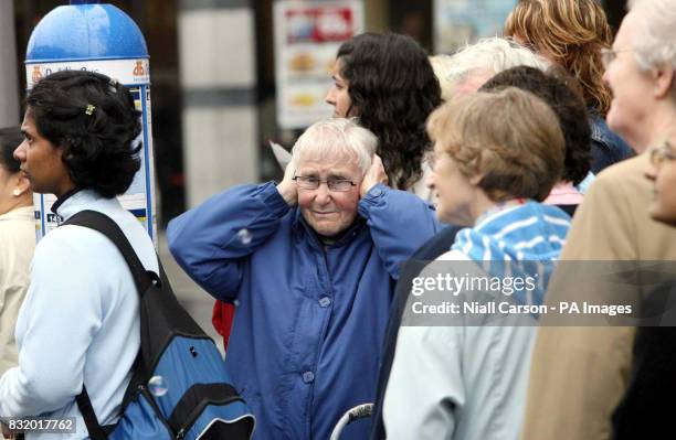 An onlooker reacts to loud dance music by putting her hands over her ears as members of Dublin's gay, lesbian and transexual community march through...