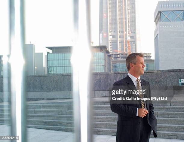 businessman contemplating, dubai cityscape in background, uae - difc stockfoto's en -beelden