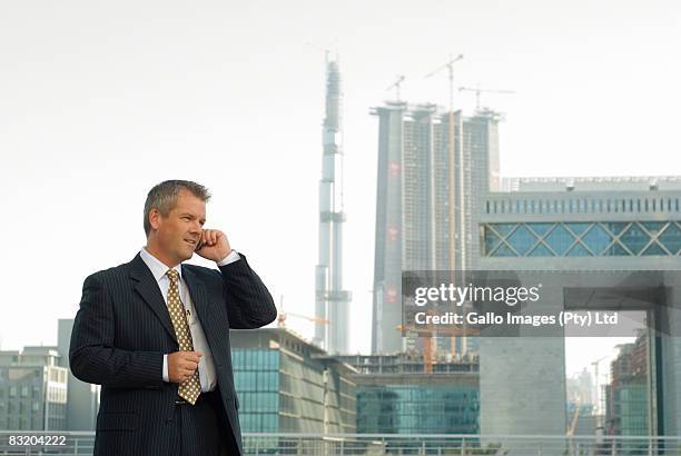 businessman on phone, dubai cityscape in background, uae - difc stockfoto's en -beelden