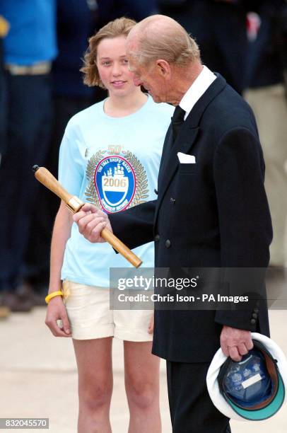 The Duke of Edinburgh looks at the commemorative belaying pin presented to him by Caroline Fryer from Dauntsey's School in Wiltshire, before...