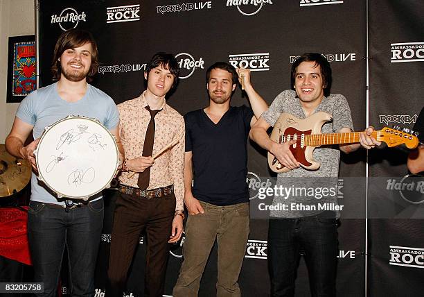 Members of the band Panic at the Disco drummer Spencer Smith, guitarist Ryan Ross, bassist Jon Walker and frontman Brendon Urie pose with memorabilia...