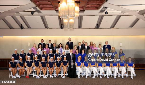 Juli Inkster the United States Team captain and Annika Sorenstam the European Team captain sit beside the Solheim Cup trophy with their teams and...