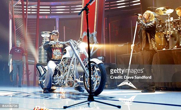 Darren McCarty of the Detroit Red Wings brings the Stanley Cup on stage as Def Leppard performs during NHL Face-Off Rocks at the Fox Theatre October...
