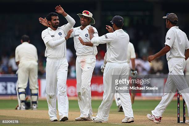 Zaheer Khan celebrates with India teammates VVS Laxman and Rahul Dravid after taking his fifth wicket of the innings and bowling Mike Hussey of...