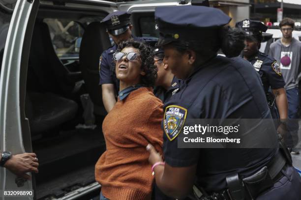 New York City Police officers detain a demonstrator during the "Defend DACA & TPS" rally outside of Trump Tower in New York, U.S., on Tuesday, Aug....