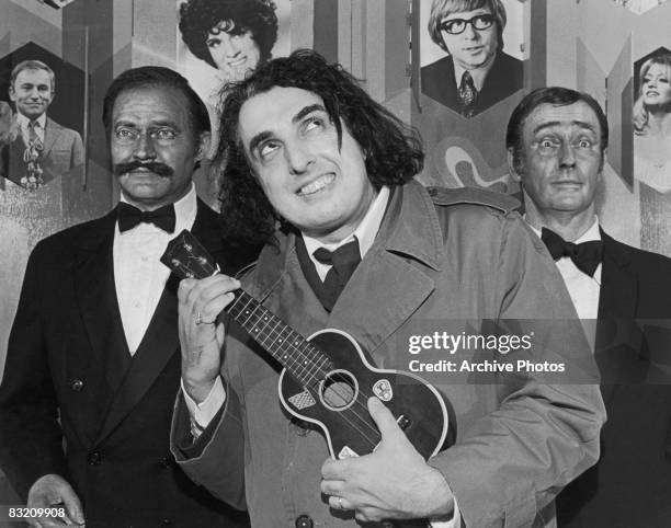 American singer and musician Tiny Tim visits the Stars Hall of Fame in Orlando, Florida, 1976. There he poses between waxworks of Dan Rowan and Dick...