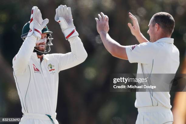 Jon Holland celebrates with Matthew Wade after dismissing Hilton Cartwright walks off after taking early wickets during day three of the Australian...