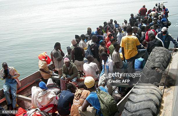 Men part of a group of 139 would-be-illegal immigrants from Gambia wait in a boat after being intercepted by police off the coast of Nouakchott on...