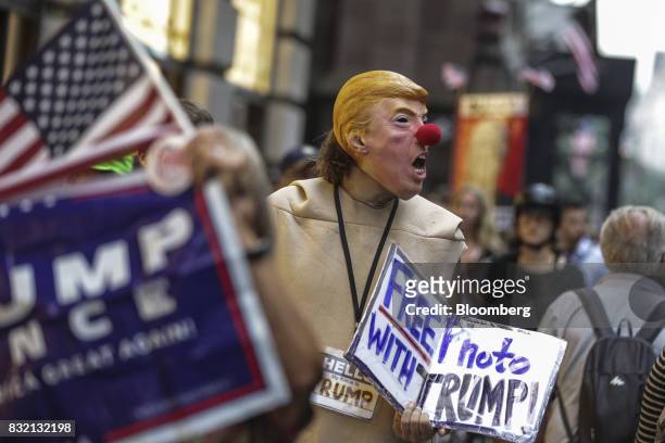 Demonstrator wears a mask in the likeness of U.S. President Donald Trump during the "Defend DACA & TPS" rally outside of Trump Tower in New York,...