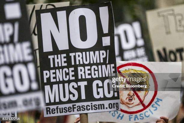 Demonstrators hold signs during the "Defend DACA & TPS" rally outside of Trump Tower in New York, U.S., on Tuesday, Aug. 15, 2017. A day after...