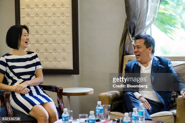 Billionaire Chen Tianqiao, founder and chairman of Shanda Group, right, and his wife Chrissy Luo, co-founder and vice chairman, react during an...