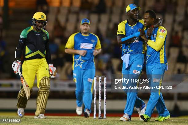 In this handout image provided by CPL T20, Marlon Samuels, Daren Sammy and Jesse Ryder of St Lucia Stars celebrate the dismissal of Kumar Sangakarra...