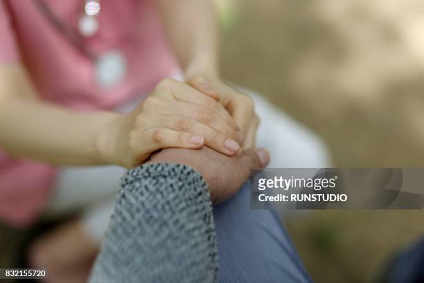 image of a nurse holding the patient's hand - doing a favor - fotografias e filmes do acervo