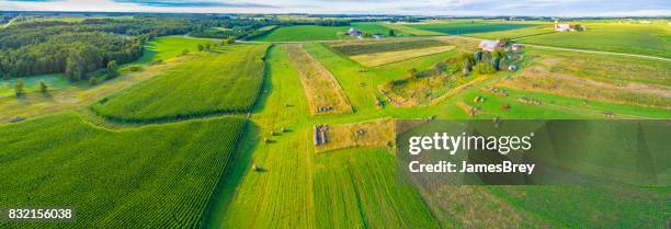 vast rural landscape with freshly baled hay, fields and farms - baled stock pictures, royalty-free photos & images