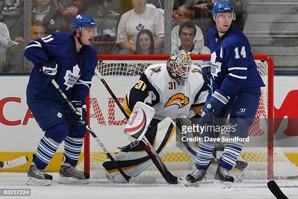 Goaltender Jonas Enroth of the Buffalo Sabres looks for the puck as Jiri Tlusty and Matt Stajan of the Toronto Maple Leafs crowd the crease during...