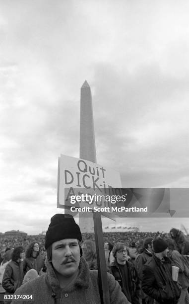 Washington, DC : A man holds an anti-Nixon sign, and gathers with thousands of others in front of the Washington Monument on a cold January day,...