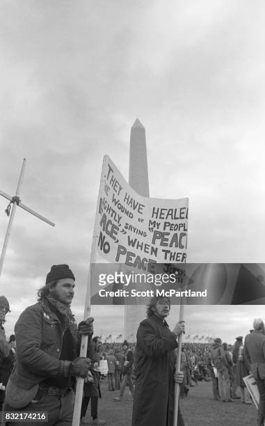 Washington, DC : Two men holding a protest sign, gather with thousands of others in front of the Washington Monument on a cold January day,...