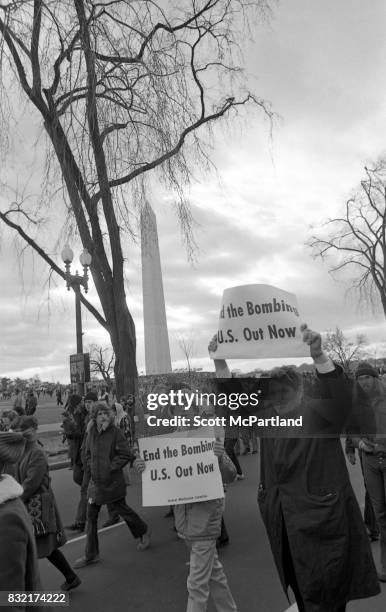 Washington, DC : Hundreds of activists holding signs, march near the Washington Monument on a cold January day, protesting the Vietnam War, and...