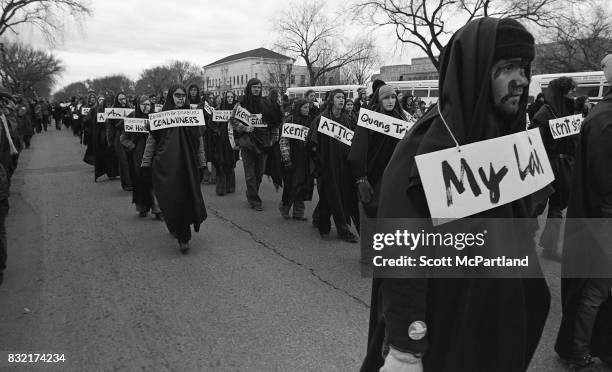 Washington, DC : Hundreds of young activists dressed in black, and wearing signs of protest around their necks, march in Washington, DC protesting...