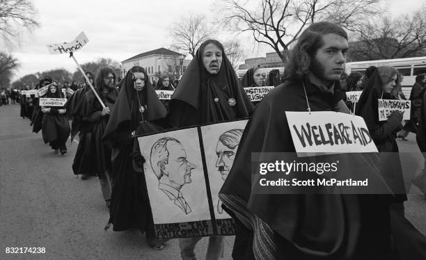 Washington, DC : Hundreds of young activists dressed in black, and wearing signs of protest around their necks, march in Washington, DC protesting...