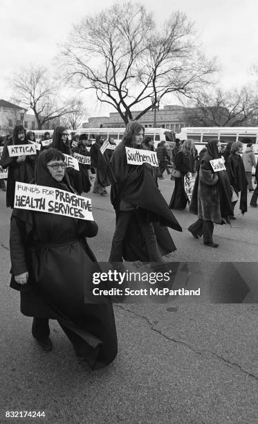 Washington, DC : Hundreds of young activists dressed in black, and wearing signs of protest around their necks, march in Washington, DC protesting...