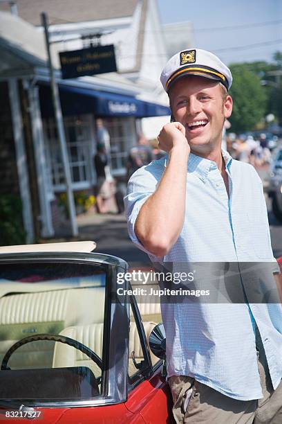 man with captains hat by convertible - white sailor hat stock pictures, royalty-free photos & images